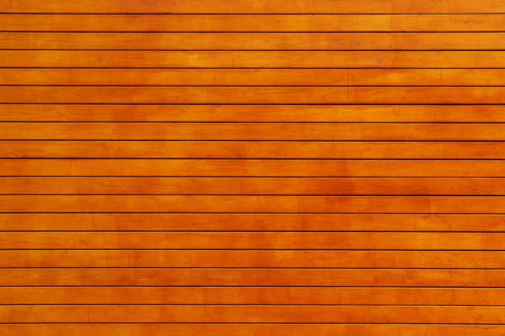 Close-up of a vibrant orange wooden wall texture, ideal for backgrounds.